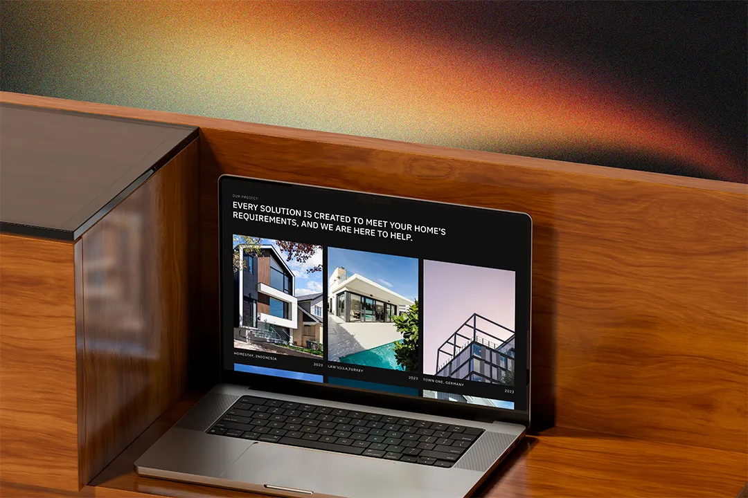A MacBook on a wooden edge showcasing Home2Stay Website